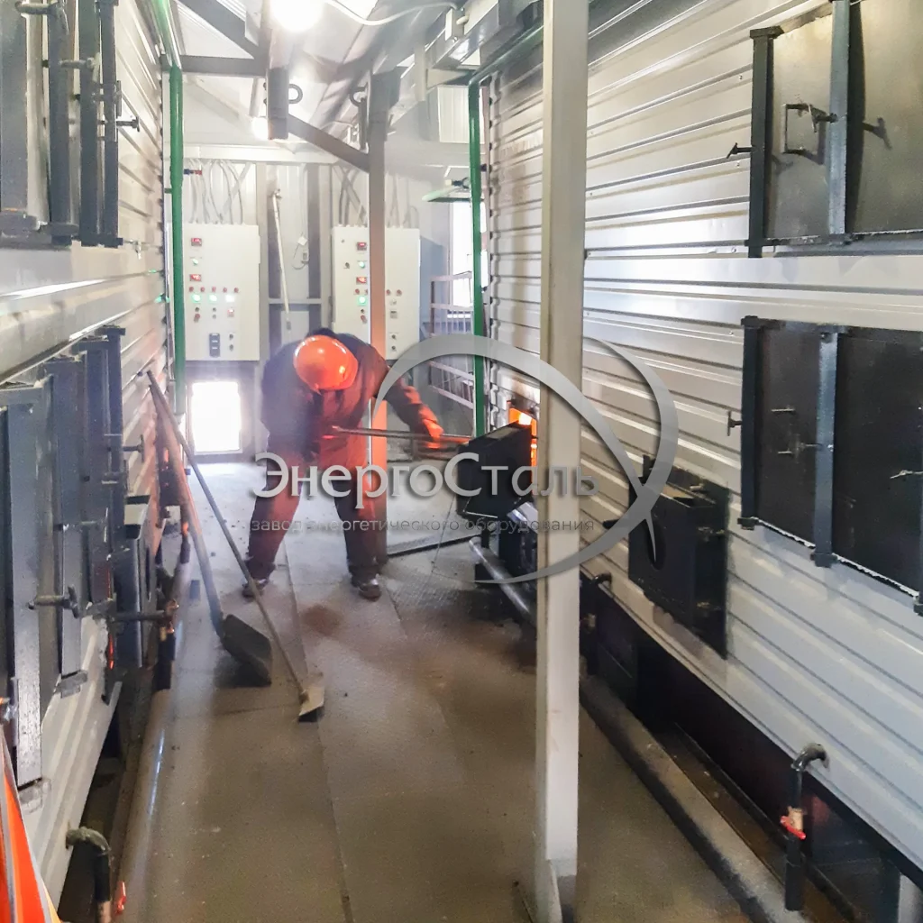 Кочегар обслуживает водогрейный котел: ручная подача угля