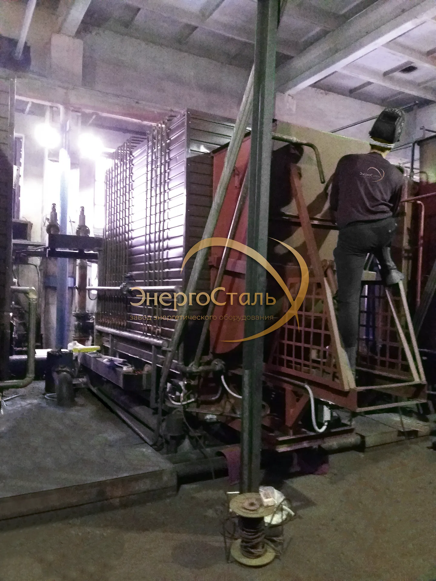 Сварщик выполняет работы при пусконаладке котла КВм в модульной котельной